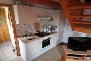 A compact kitchen with a built-in oven, a coffee maker, and a small sink. - Holiday home with 2 bedrooms (Krautsand)