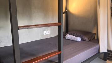 A bunk bed with a wooden frame, a grey mattress, and a pillow.