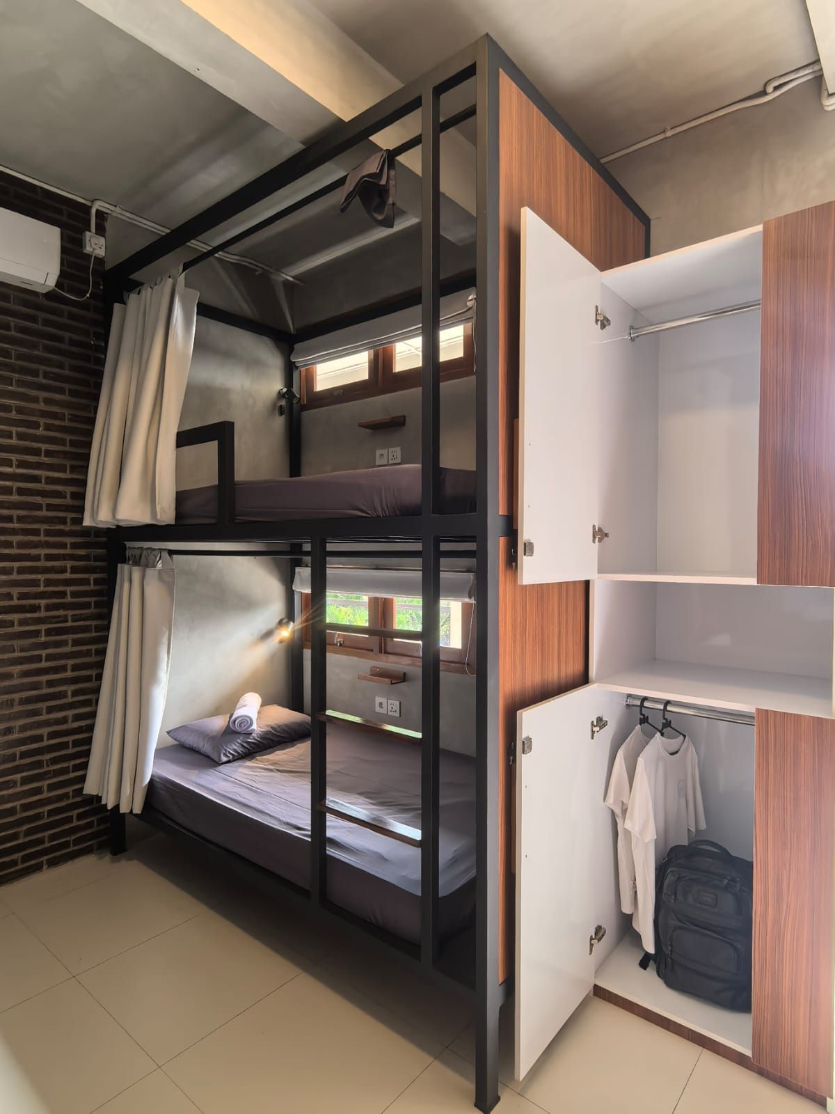 Ein Schlafraum mit Etagenbetten, einem Holzschrank und einem kleinen Kleiderschrank.