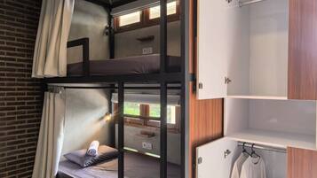A bunk bed room with a wooden wardrobe and a small closet.