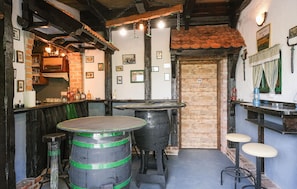 A rustic bar area with wooden barrels, stools, and a brick wall. - 4 bedroom nice home in Jastrebarsko (Dragovanscak)