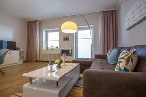 A modern living room with a sofa, a coffee table, and a television. - in the sea view apartment in Binz (Binz)