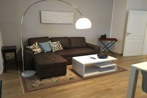 A living room with a brown sofa, a white coffee table, a floor lamp, and a patterned rug. - in the sea view apartment in Binz (Binz)