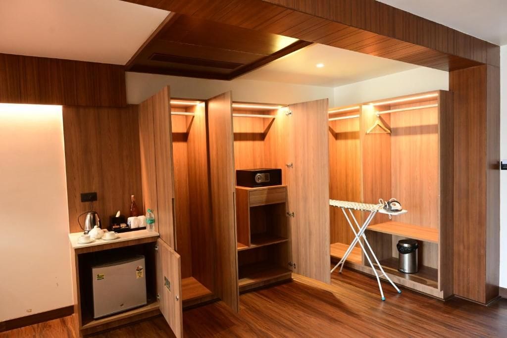 A compact room with wooden paneling, a small kitchenette, and a drying rack.