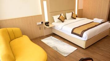 A hotel room with a bed, bedside table, chair, and a rug.