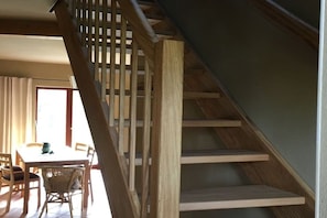 A staircase with wooden steps and a railing, leading to an upper floor. - Holiday home with 3 bedrooms (Laasow\/ Vetschau)