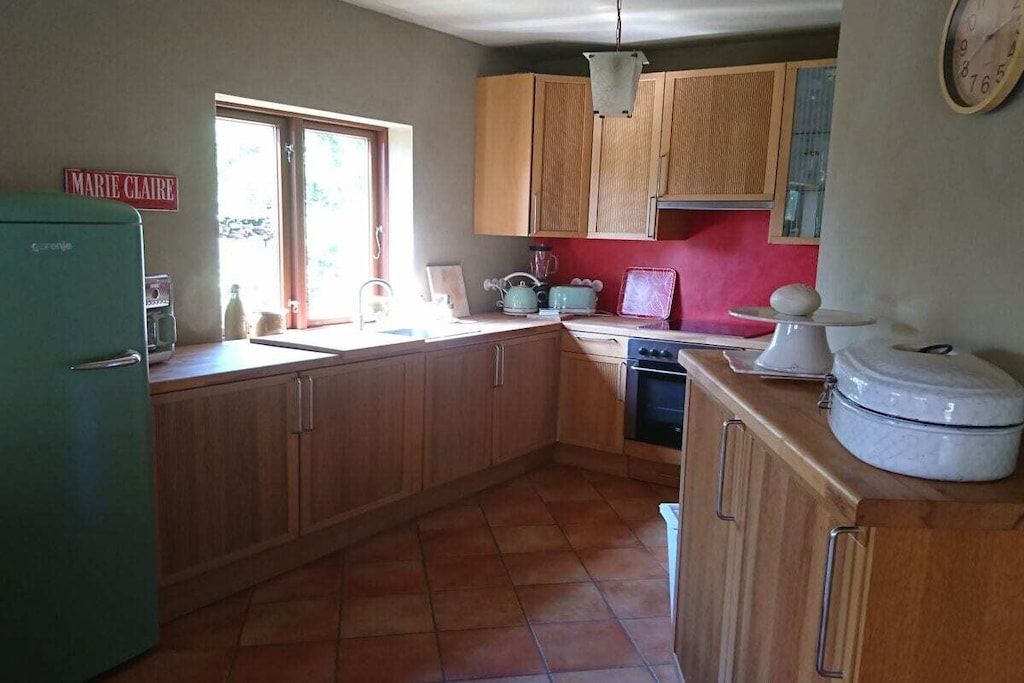 A kitchen with wooden cabinets, a sink, a stove, and a refrigerator.
