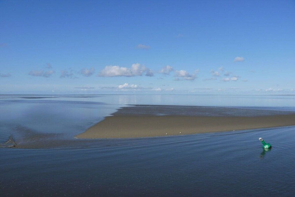 A beach with a clear sky and calm water.