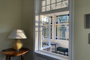 Une pièce avec une fenêtre, une lampe et une chaise.