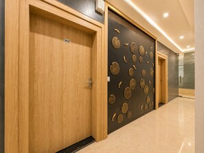 Un pasillo con puertas de madera, numeradas 302, y una pared con diseños circulares.