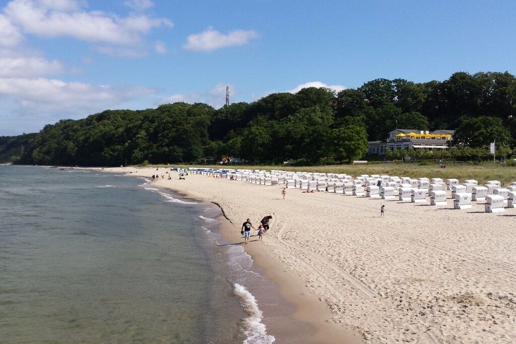 A beach with white umbrellas and a sandy shore.