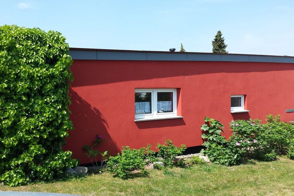 A red building with a window and a small balcony.