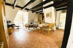 A spacious living area with a dining table, sofas, and a fireplace. - Wendt Forestry House "Waldblick" (Timmendorfer Strand)