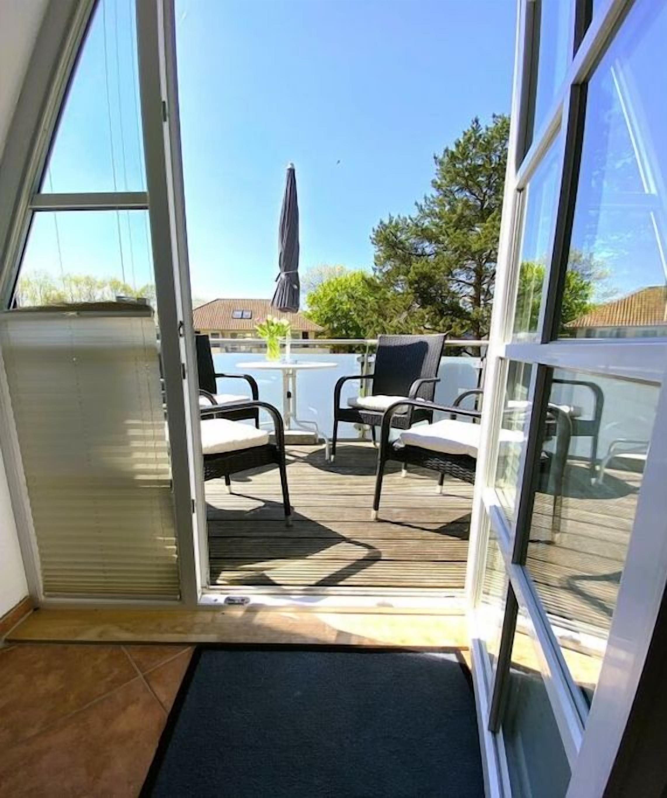 A patio area with a table and chairs, a sliding glass door, and a view of the outdoors.