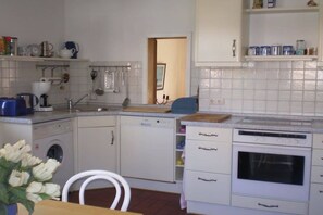 Eine kompakte Küche mit Waschmaschine, Geschirrspüler und Backofen.