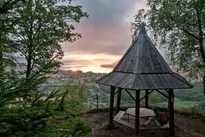 Un belvédère en bois, surmonté d’un toit conique, qui offre une vue sur une vallée.