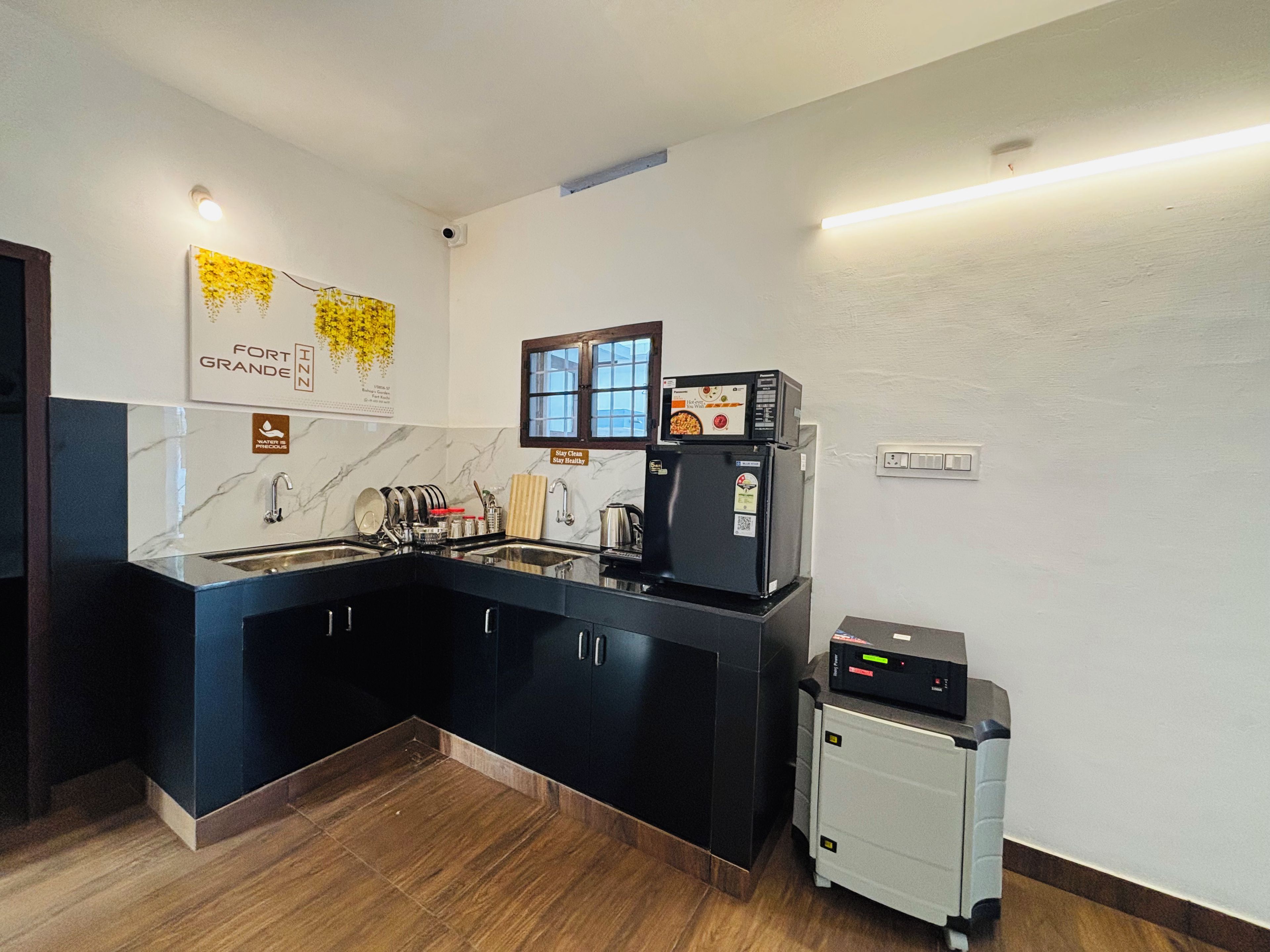 A modern kitchen with a black countertop, a built-in oven, and a small refrigerator.
