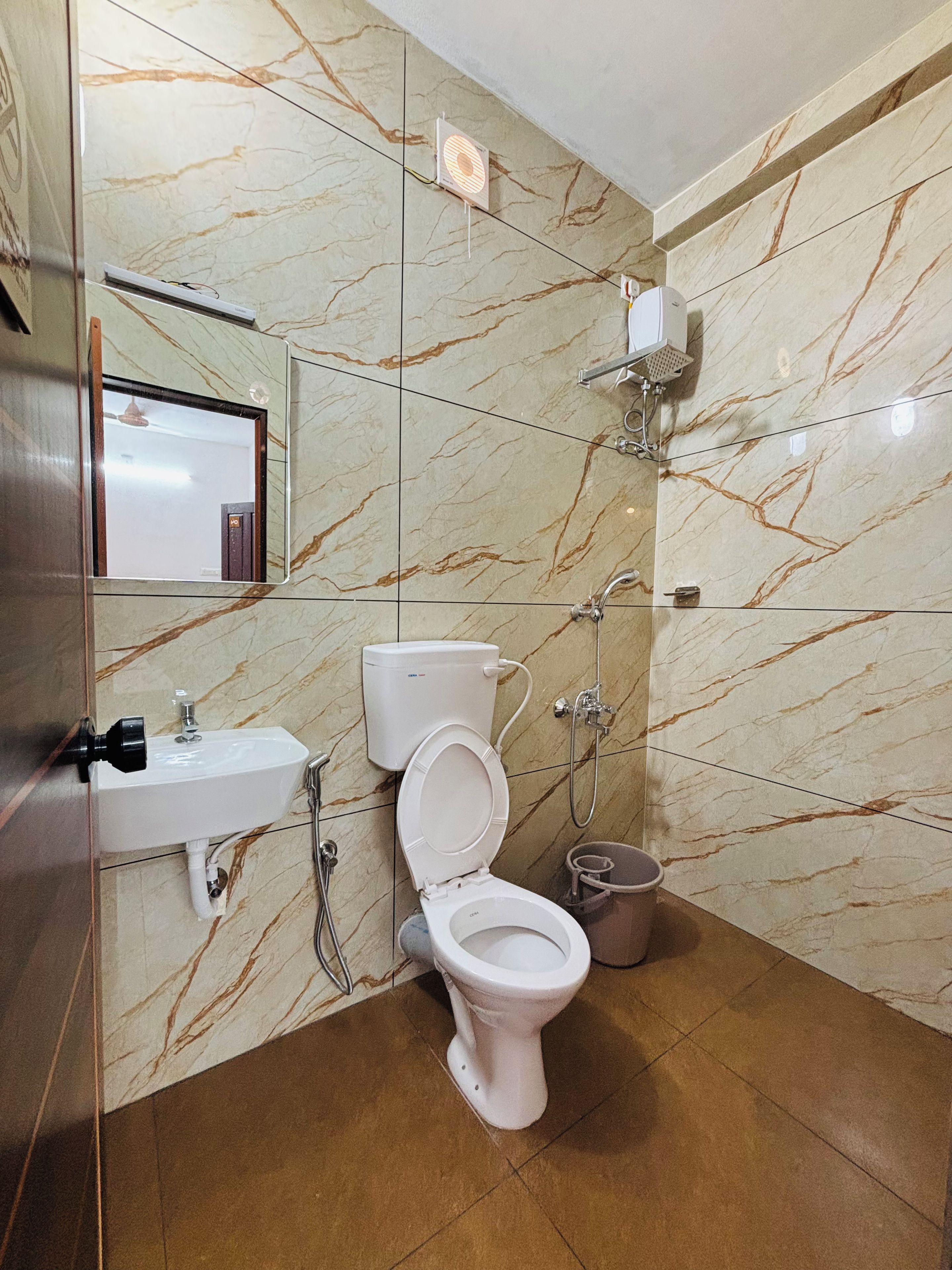 Un baño con inodoro, lavabo y ducha.