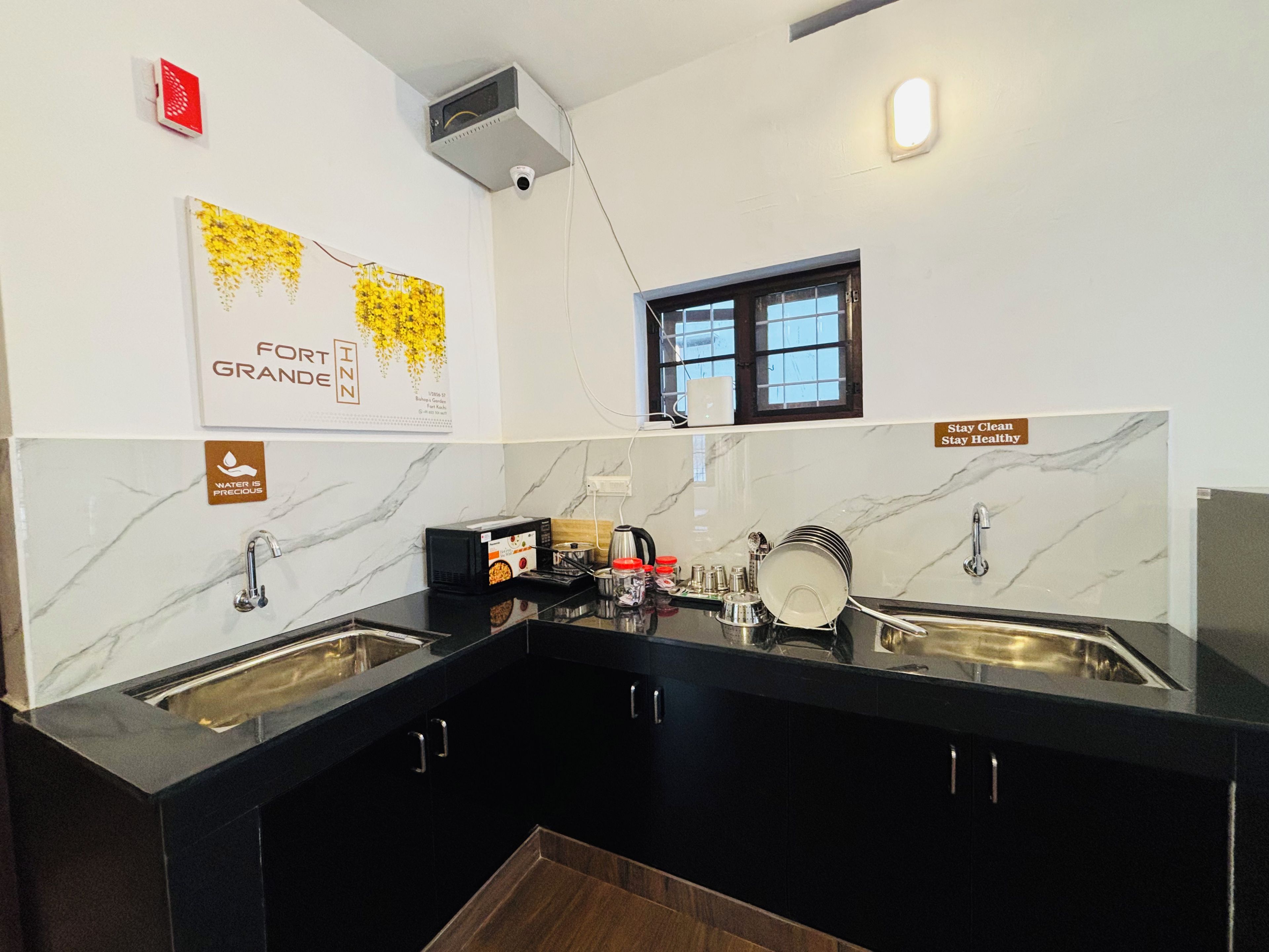 Una cocina moderna con dos fregaderos, encimeras negras, salpicadero de mármol y una ventana con vistas.