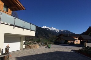 A modern building with a garage, a mountain view, and a paved driveway. - Holiday apartment with 2 bedrooms (Dorfgastein)