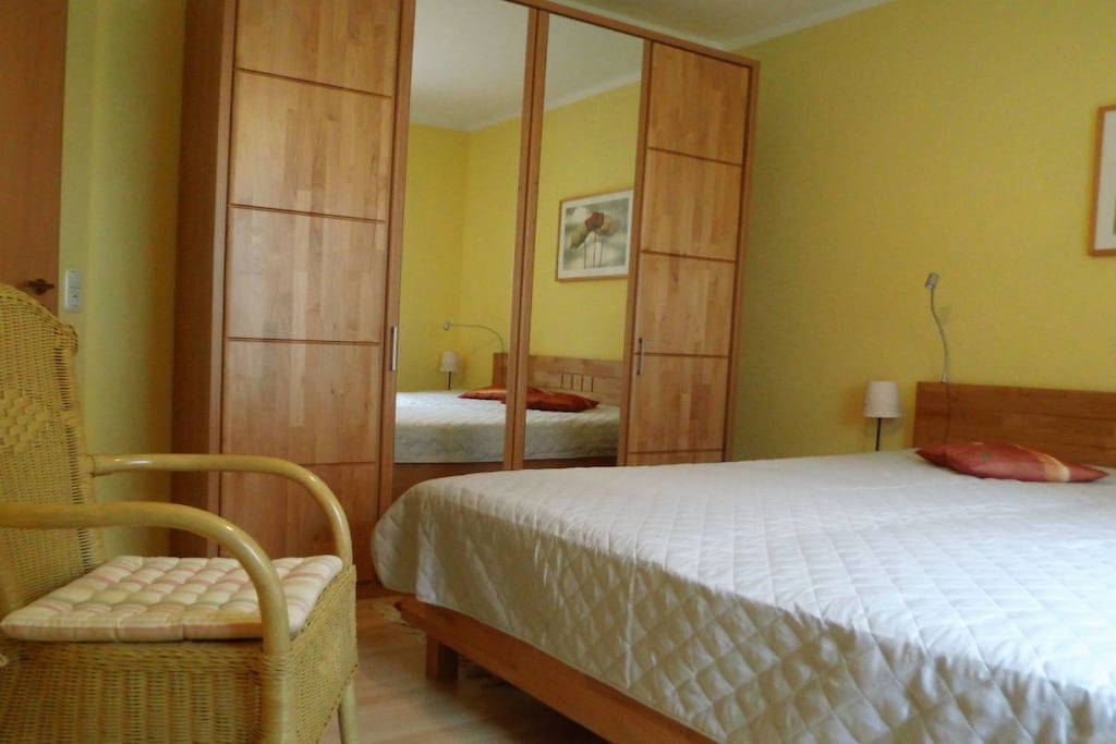 Une chambre à coucher avec un lit, une chaise et une armoire.