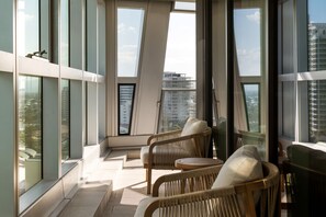 A modern interior with large windows, wicker furniture, and a view of the cityscape. - Westlight by Aryve | Surfers Paradise (Surfers Paradise)