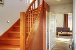 A wooden staircase leading to a room with a sofa and a coffee table. - Holiday home in Zingst with swimming pool (Zingst)
