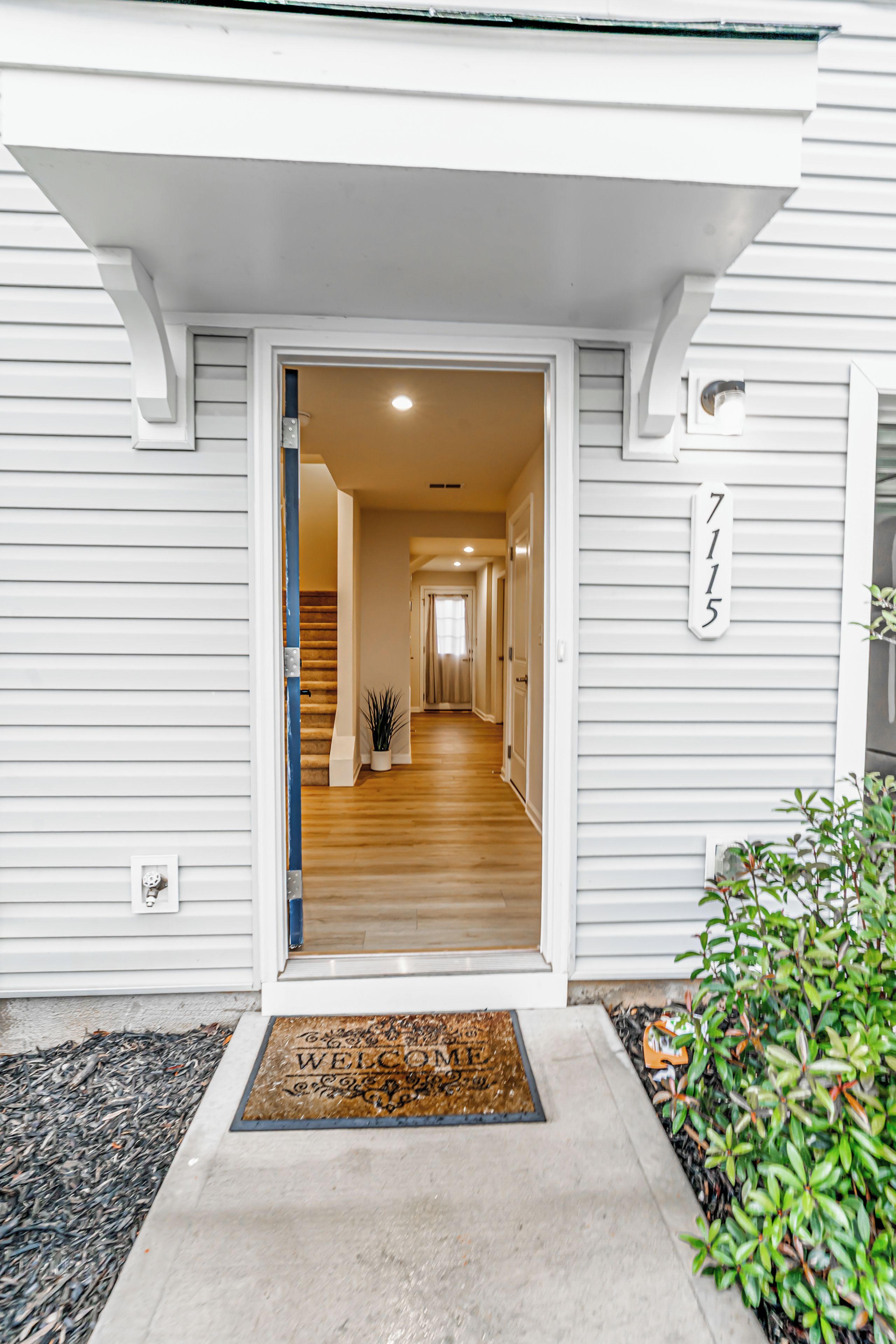 A house entrance with a wooden staircase leading to the upper floor.