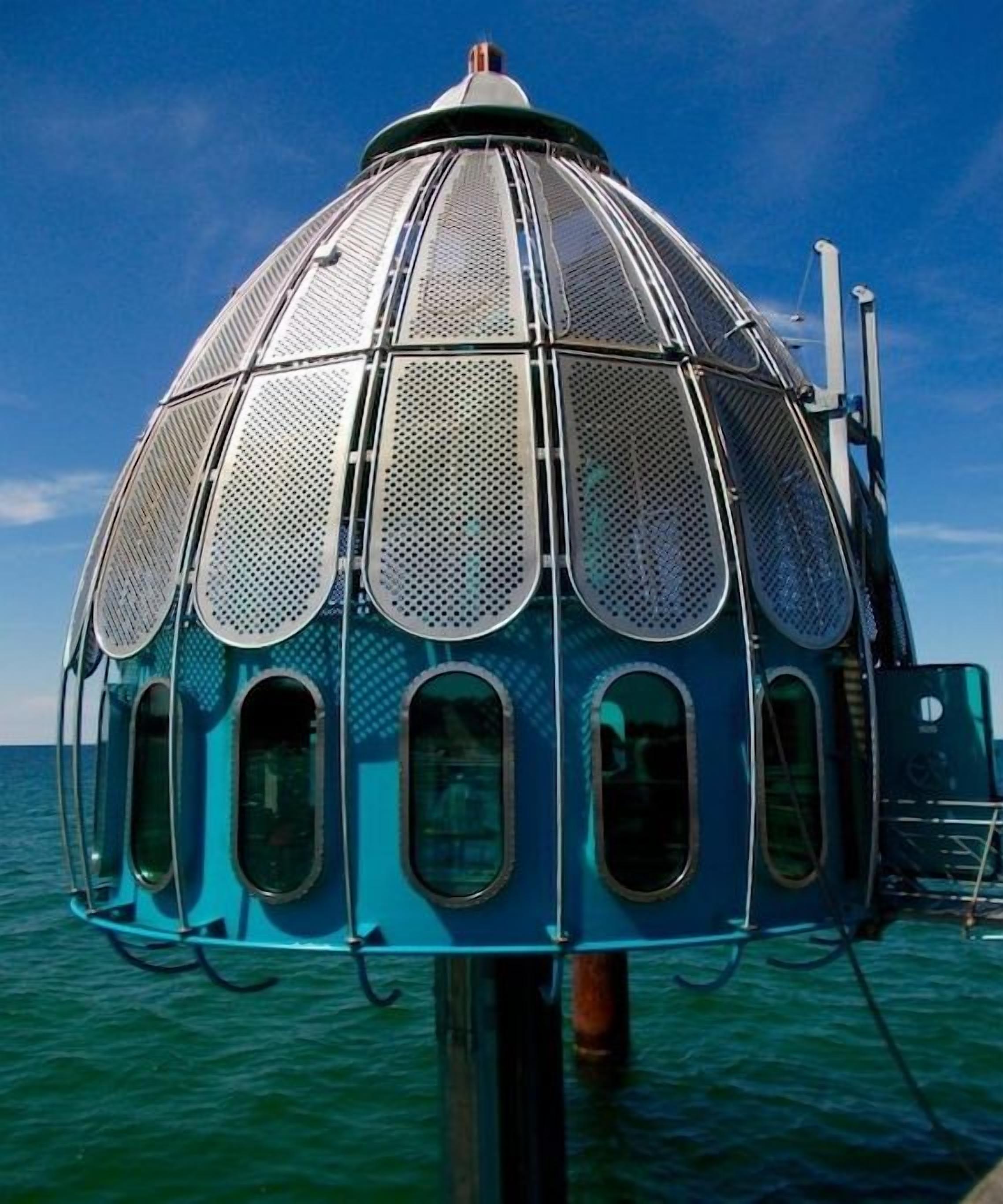 Una estructura en forma de cúpula con varias ventanas, probablemente un mirador, ubicada sobre el agua.