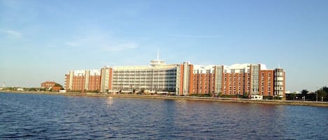 Un grand hôtel à étages, doté d’une cour intérieure, situé au bord d’un plan d’eau.