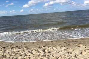 A beach with waves approaching the shore. - Holiday apartment with 2 bedrooms (Wilhelmshaven)