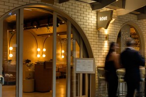Un restaurant dont l’entrée est marquée par des arcades et sur lequel on peut lire l’inscription « kost ».