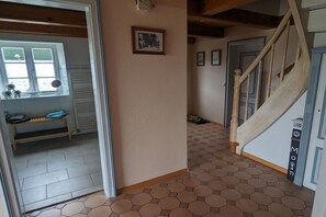A hallway with a wooden staircase, a bench, and a door with a sign. - Holiday home in Ockholm with barbecue (Ockholm)