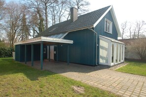 A two-story house with a covered patio and a large window on the second floor. - Holiday home with 2 bedrooms (Ostseebad Prerow)