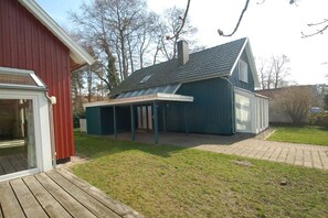 A two-story house with a covered patio area. - Holiday home with 2 bedrooms (Ostseebad Prerow)