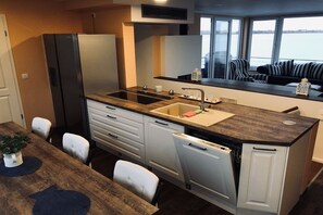 A compact kitchen with a sink, stove, and white cabinets. - Holiday home with 2 bedrooms (Bitterfeld)