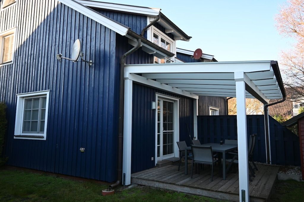 A blue house with a covered patio area, a window, and a door.