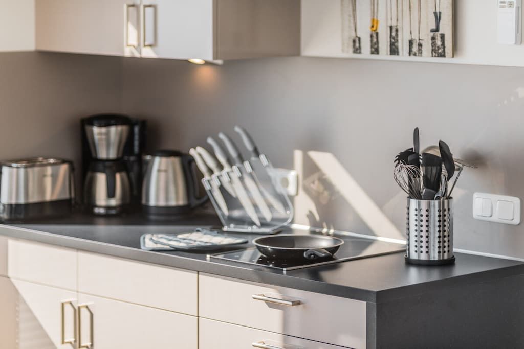 Eine moderne Küche mit einem Gasherd, einer Kaffeemaschine und einem Messerset auf der Arbeitsfläche.