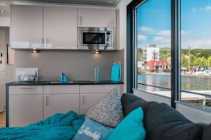 A compact kitchenette with a microwave, a radio, and a sink.