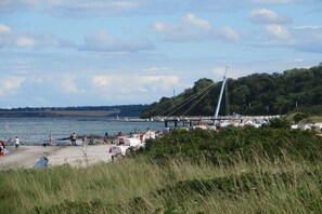 A beach with a bridge, grassy areas, and a body of water. - Holiday apartment with 1 bedroom (Hohwacht (Ostsee), Deutschland)