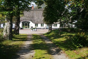 A pathway leading to a building with a thatched roof and white walls. - Holiday home in Schlei with 2 bedrooms (Klappholz)