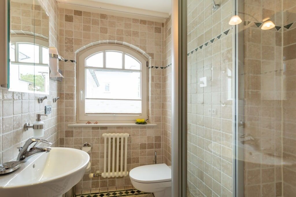 Un baño con bañera, inodoro y ventana.