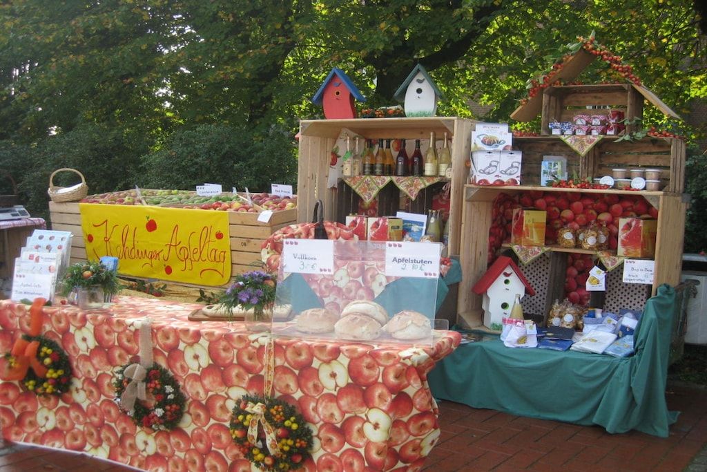 A fruit stand with various apples and a sign indicating a special offer.