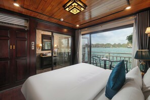 A hotel room with a large bed, a bathroom with a glass door, and a view of the sea. - Halong Arcadia Cruise (Ha Long)