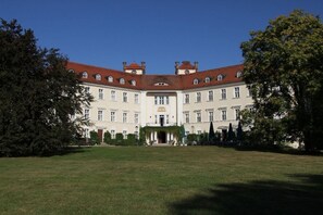 A large, symmetrical building with a central entrance, surrounded by a well-maintained lawn. - Holiday apartment with 1 bedroom (Lübbenau)