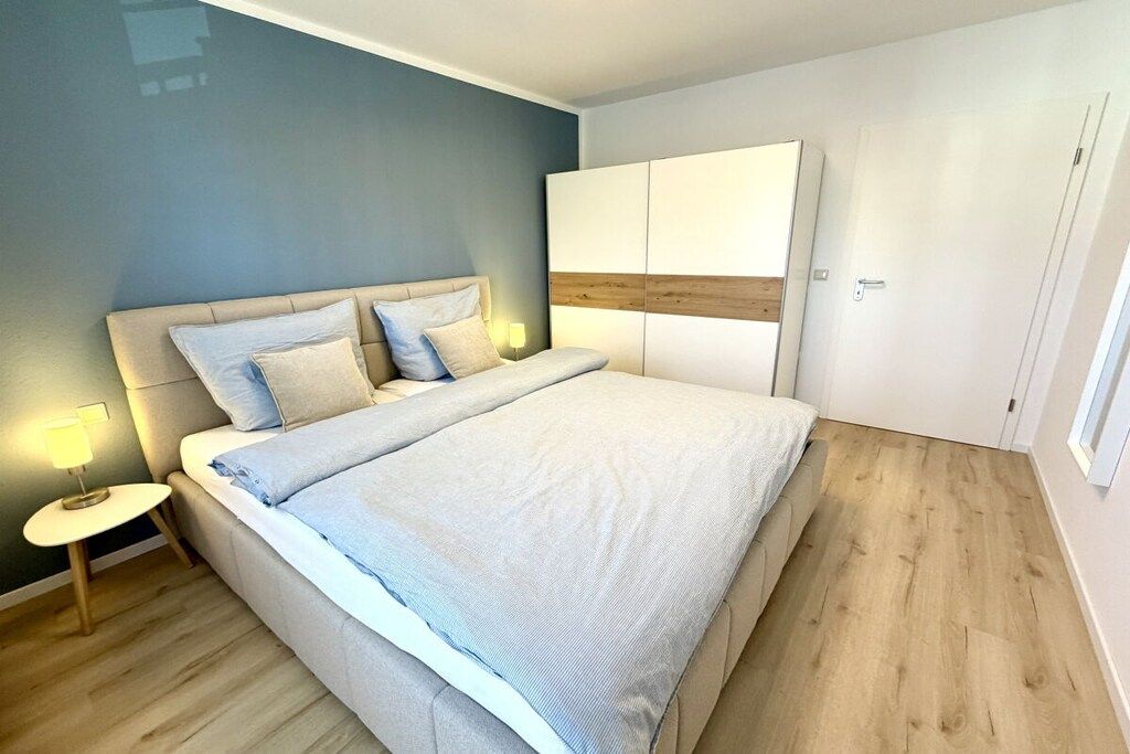 Un dormitorio con cama, mesitas de noche y armario.