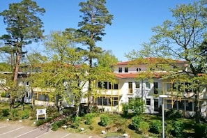 A multi-story building with a central courtyard, surrounded by trees and greenery. - Holiday apartment KÜSTENNEST Baabe (Baabe)