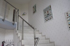 A staircase with metal handrails, a wall-mounted coat rack, and framed pictures on the wall. - Holiday apartment in Süsel with swimming pool (Süsel)