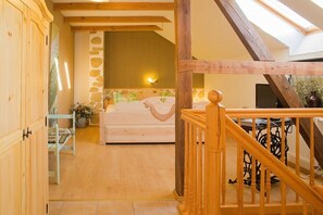 A bedroom with a bed, a nightstand, a lamp, and a window. - Stein - Apartment Storchenblick (Byhleguhre)