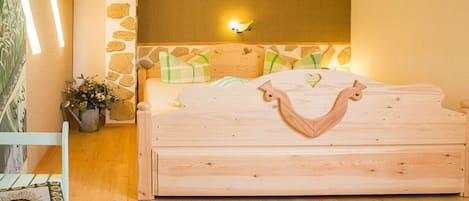 Un dormitorio con una cama de madera, una pared de acento de piedra y una lámpara de pared.